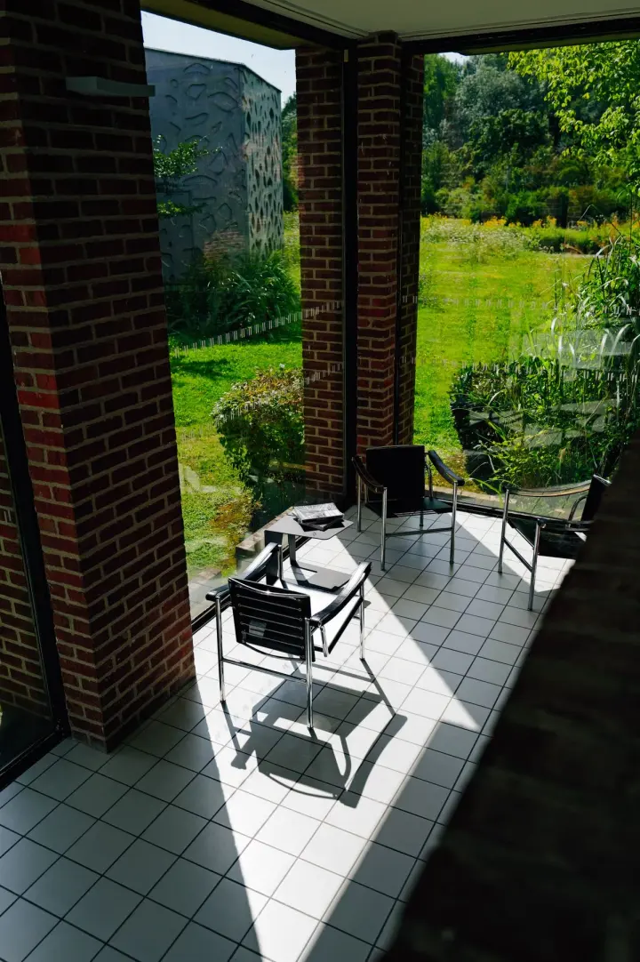 Garden with lush planting and a tiled patio with outdoor chairs